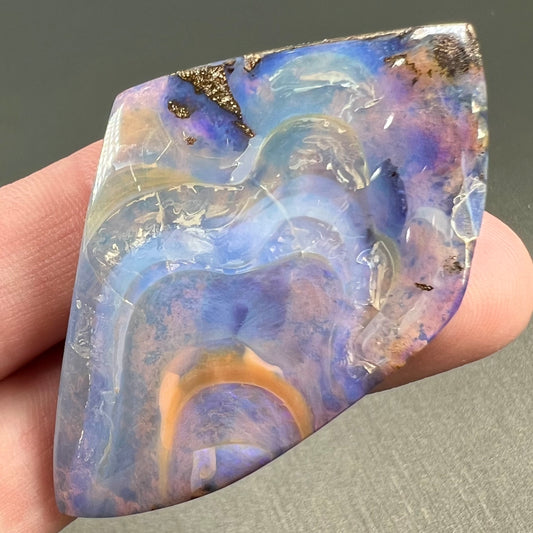 A polished, purple Quilpie boulder opal stone from Queensland, Australia.