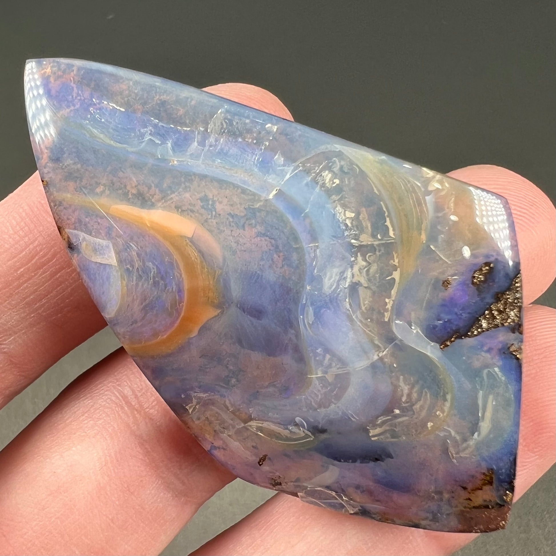 A polished, purple Quilpie boulder opal stone from Queensland, Australia.