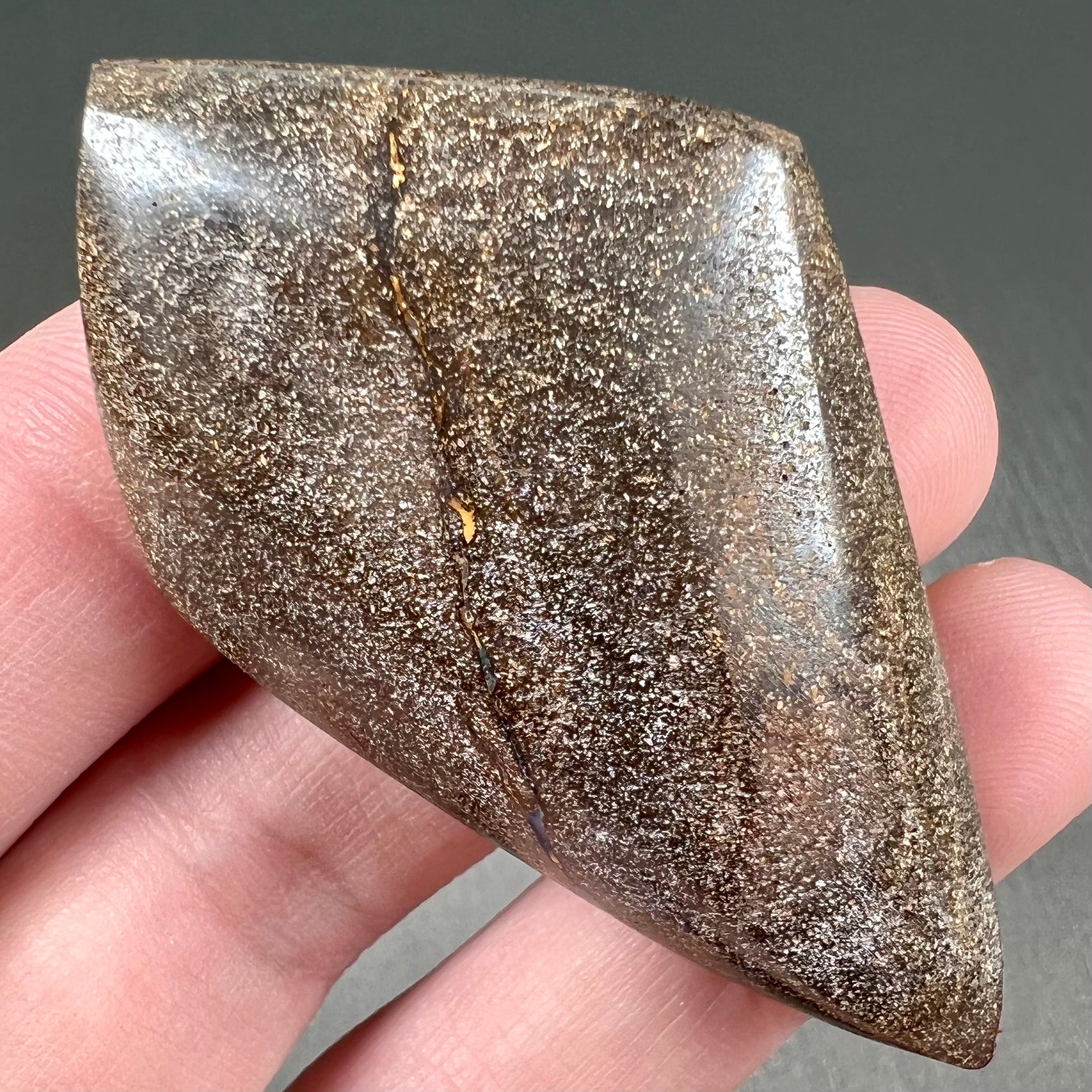 A polished, purple Quilpie boulder opal stone from Queensland, Australia.