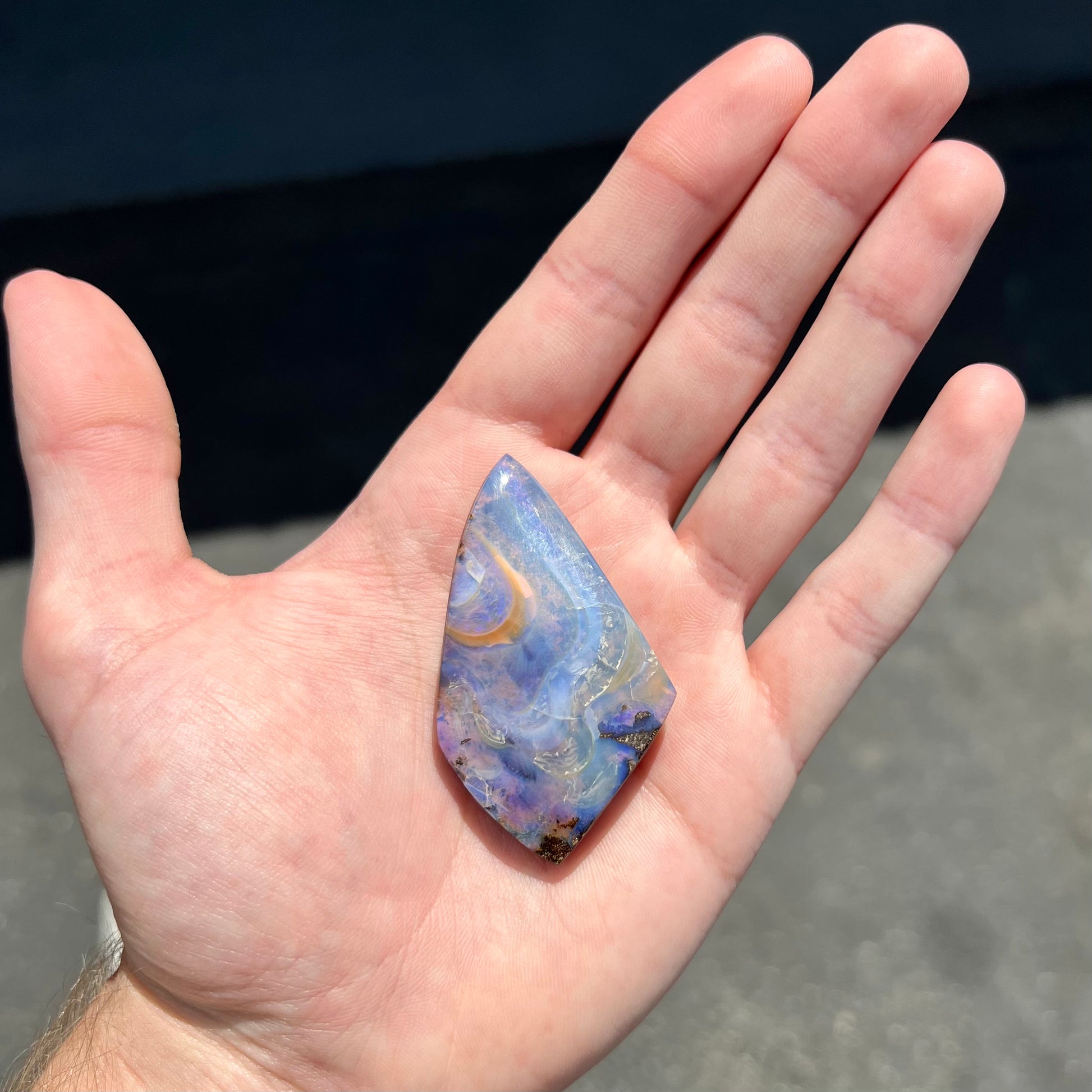 A polished, purple Quilpie boulder opal stone from Queensland, Australia.
