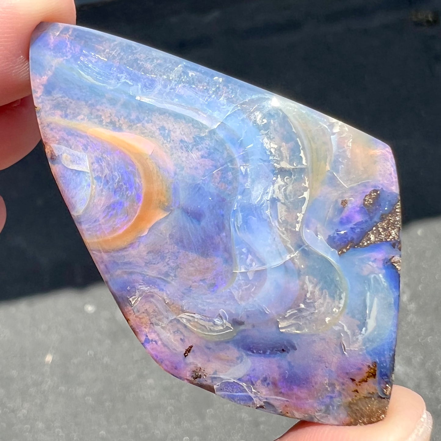 A polished, purple Quilpie boulder opal stone from Queensland, Australia.