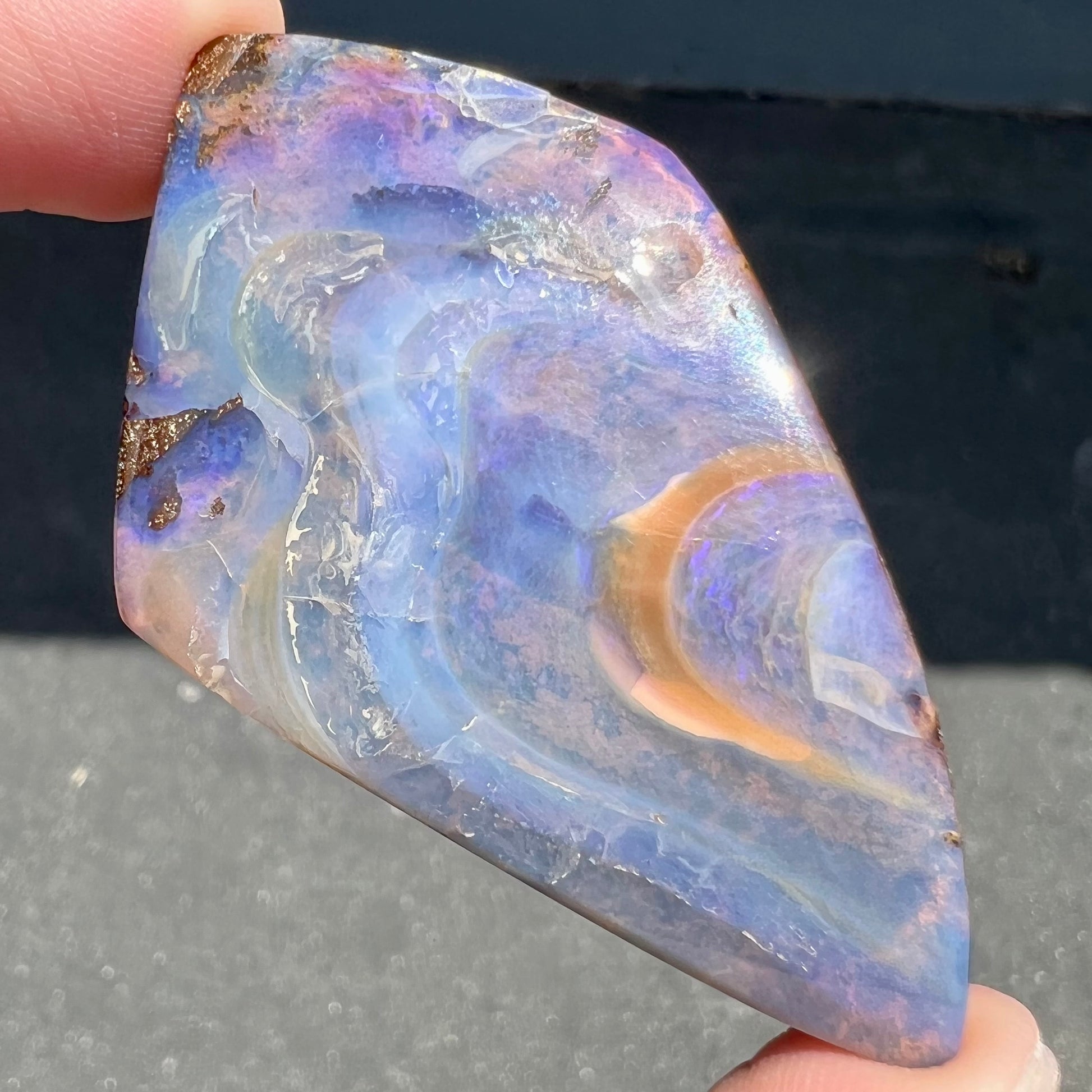 A polished, purple Quilpie boulder opal stone from Queensland, Australia.