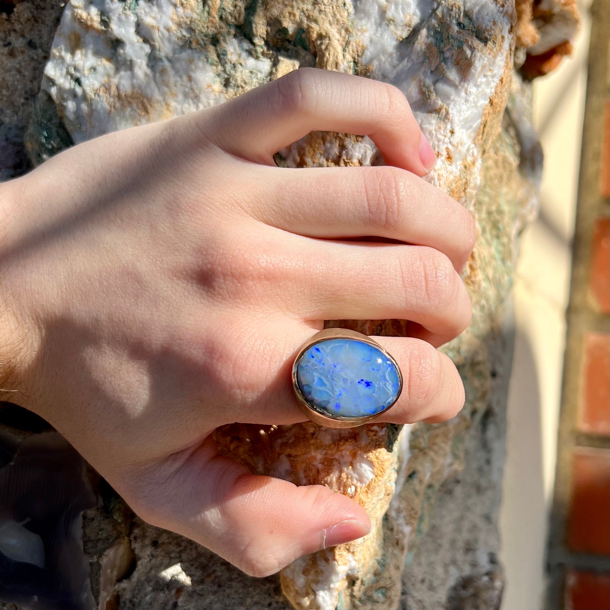 A Lightning Ridge black opal men's ring in solid yellow textured gold.
