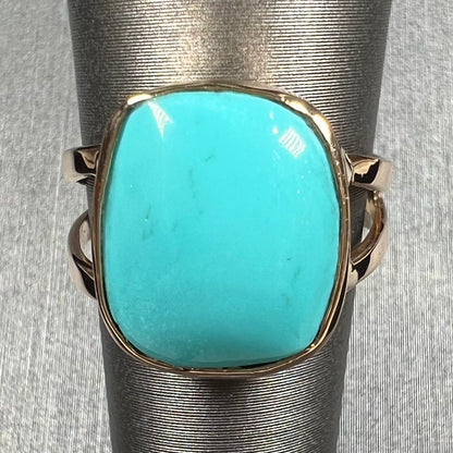 A handmade split shank ring set with Sleeping Beauty turquoise in yellow gold.