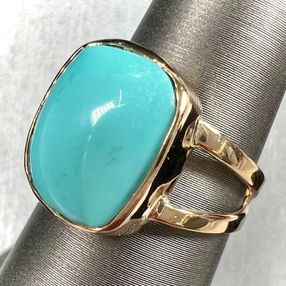 A handmade split shank ring set with Sleeping Beauty turquoise in yellow gold.