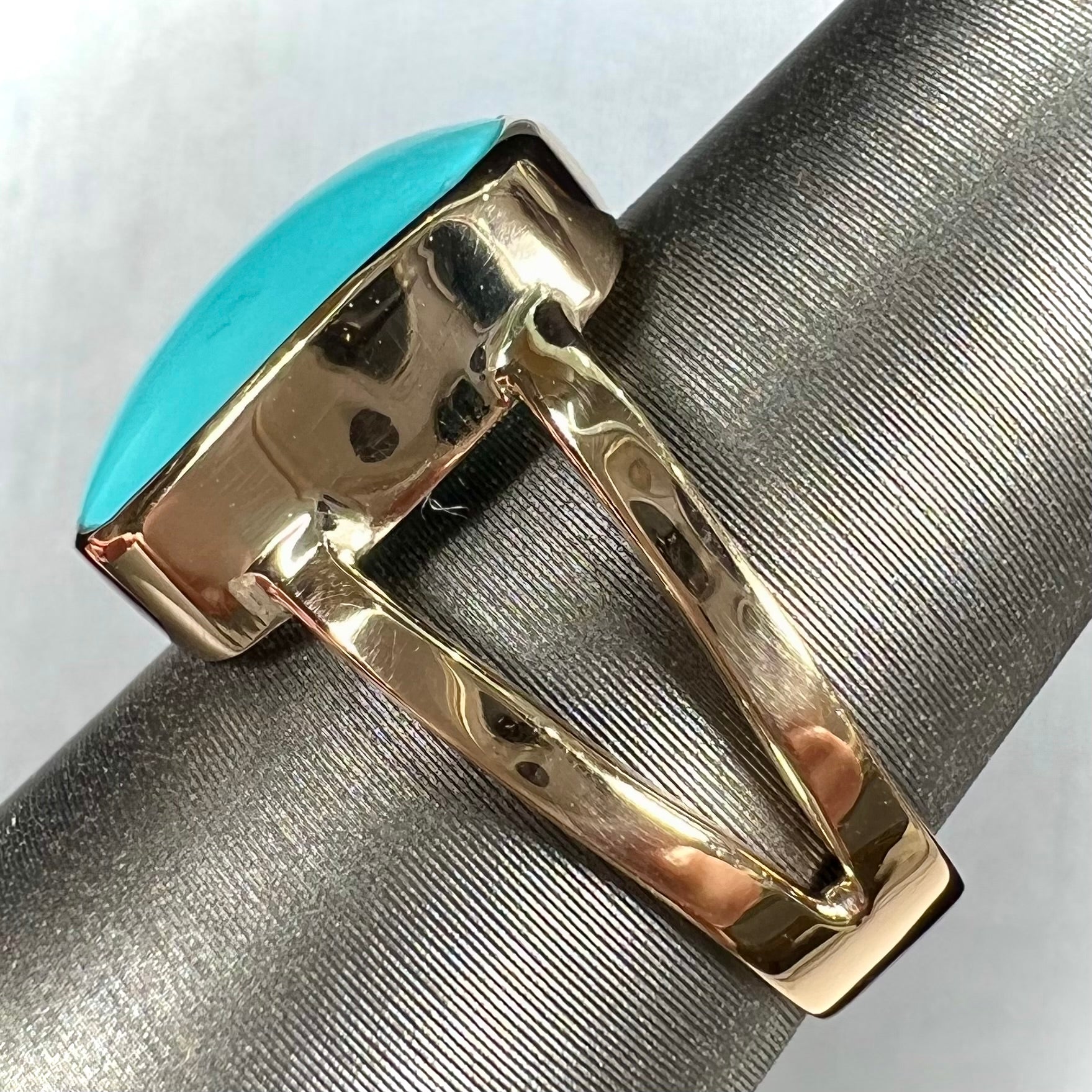 A handmade split shank ring set with Sleeping Beauty turquoise in yellow gold.