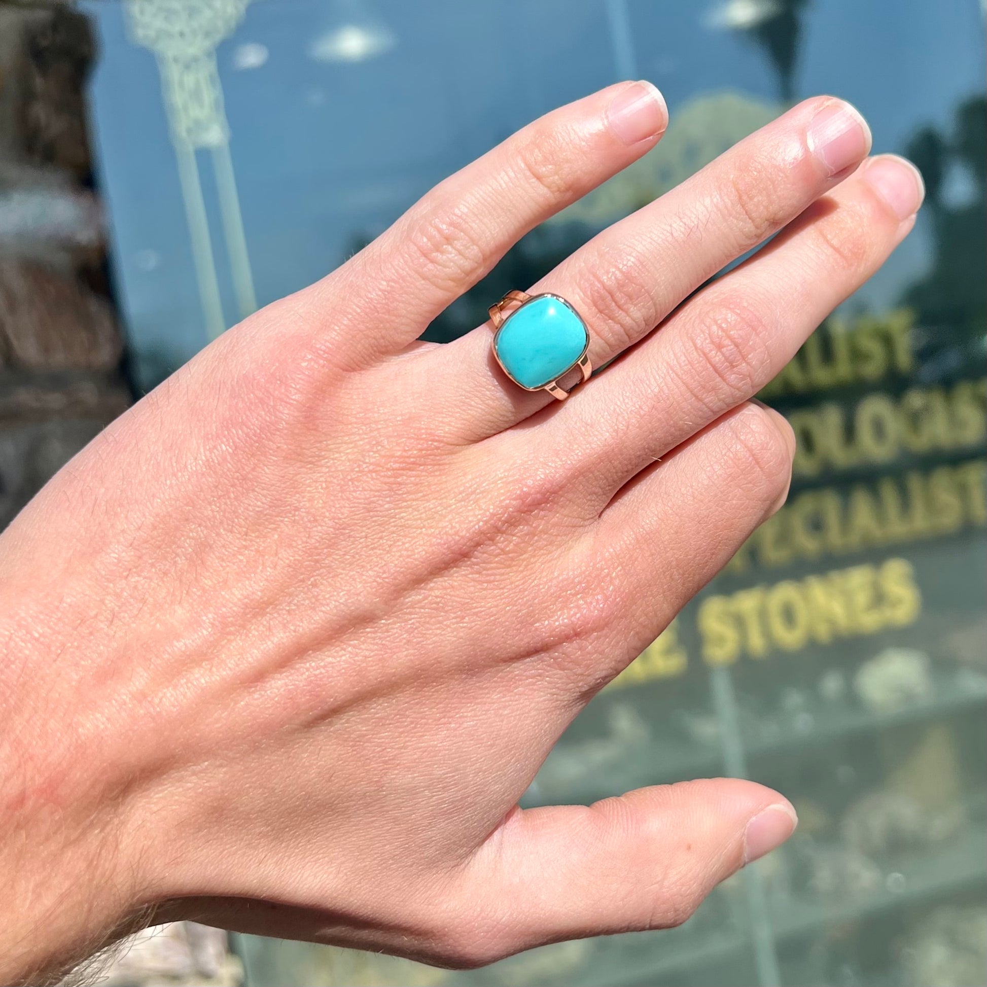 A handmade split shank ring set with Sleeping Beauty turquoise in yellow gold.