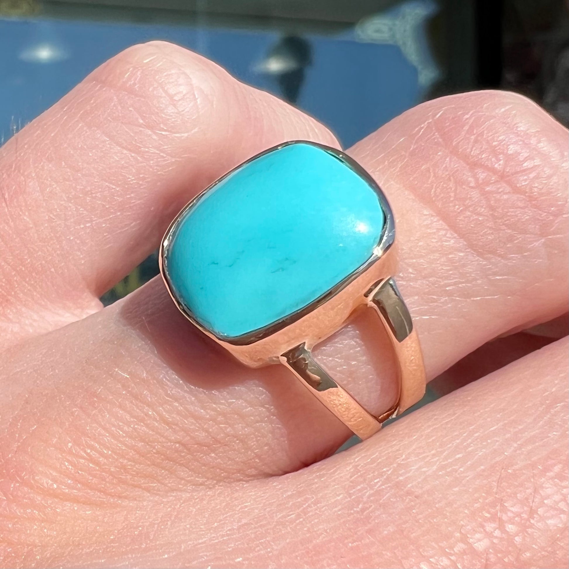 A handmade split shank ring set with Sleeping Beauty turquoise in yellow gold.