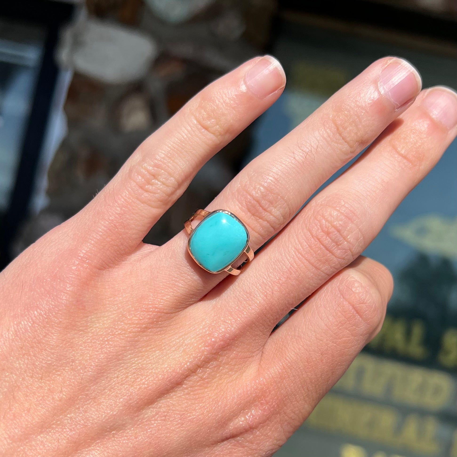 A handmade split shank ring set with Sleeping Beauty turquoise in yellow gold.