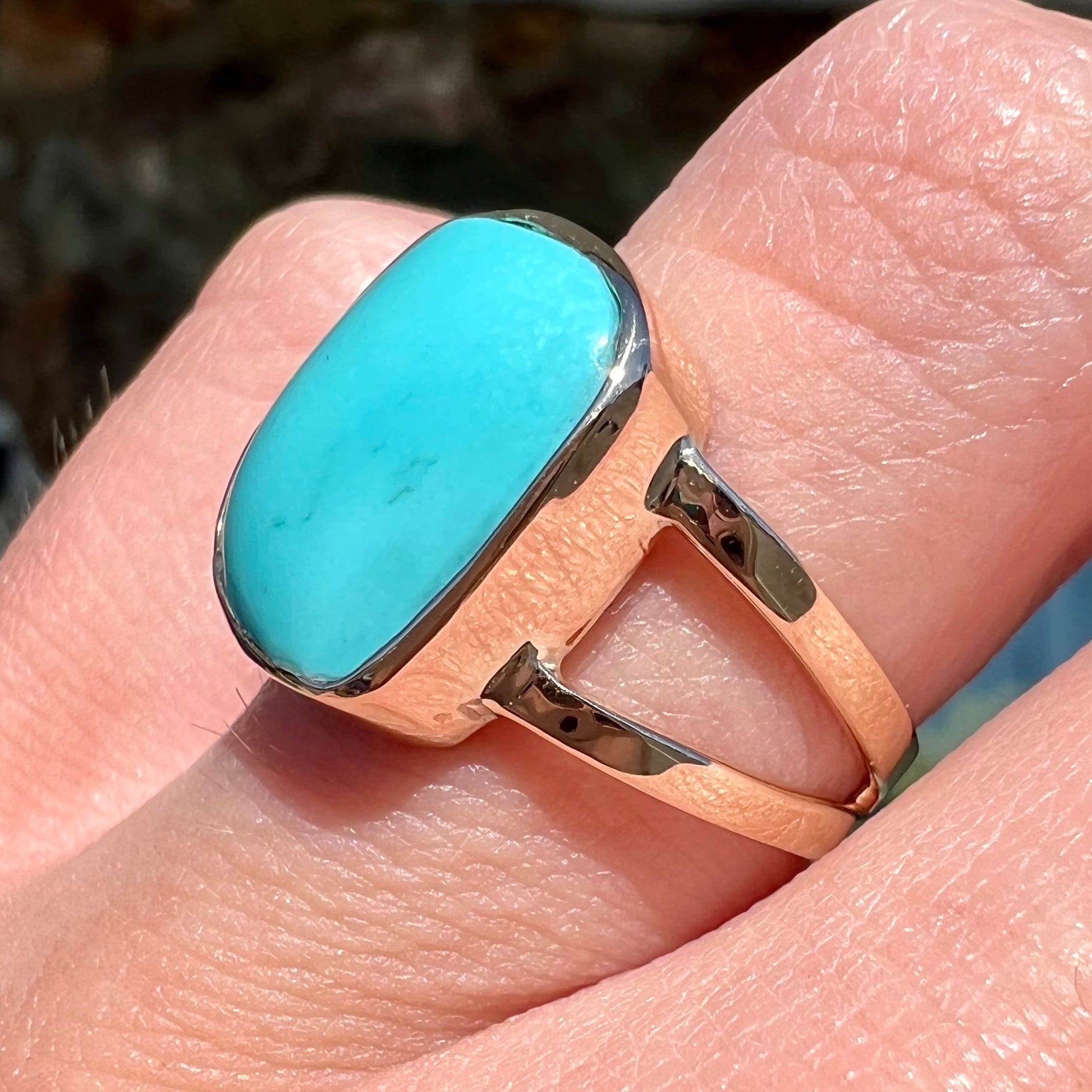 A handmade split shank ring set with Sleeping Beauty turquoise in yellow gold.