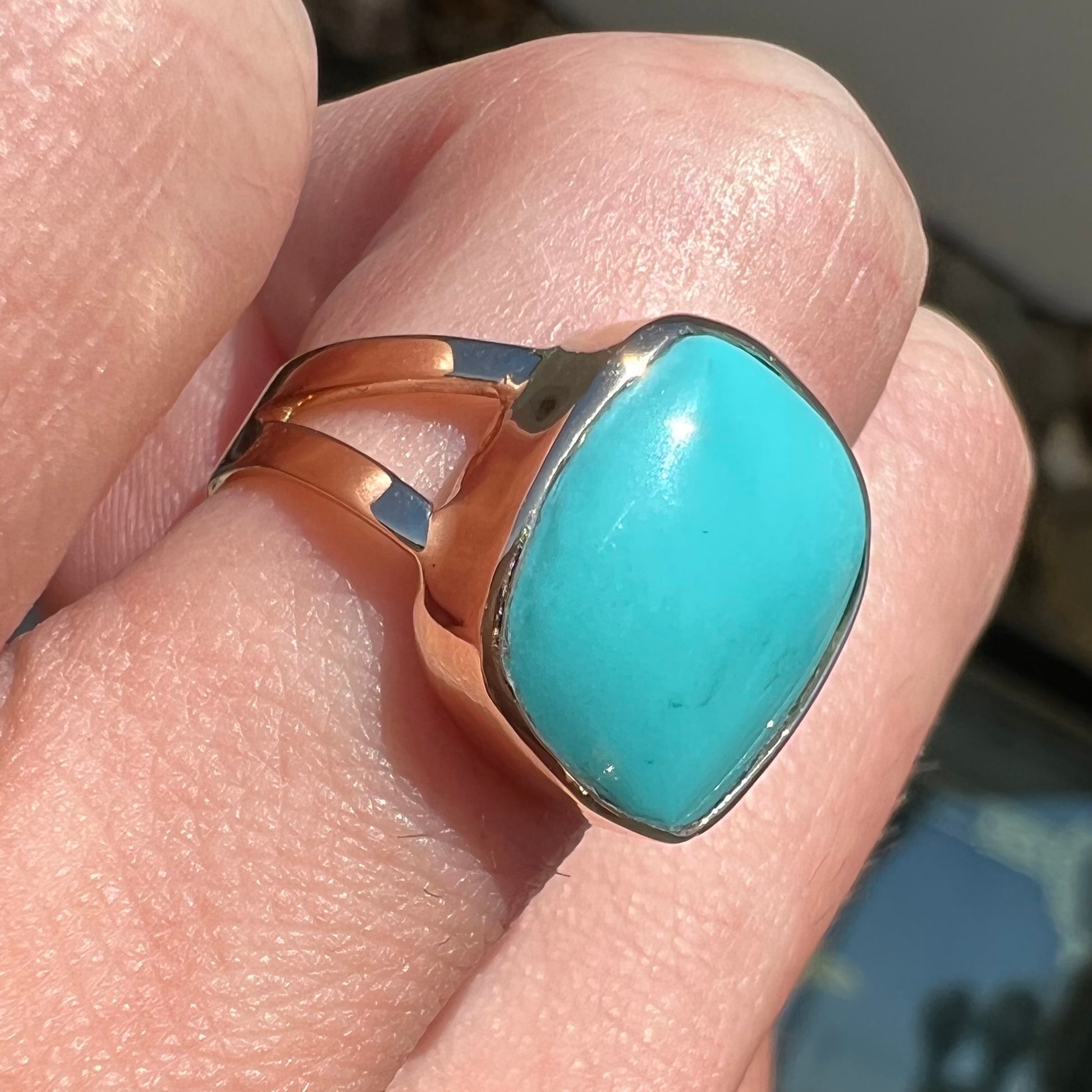 A handmade split shank ring set with Sleeping Beauty turquoise in yellow gold.