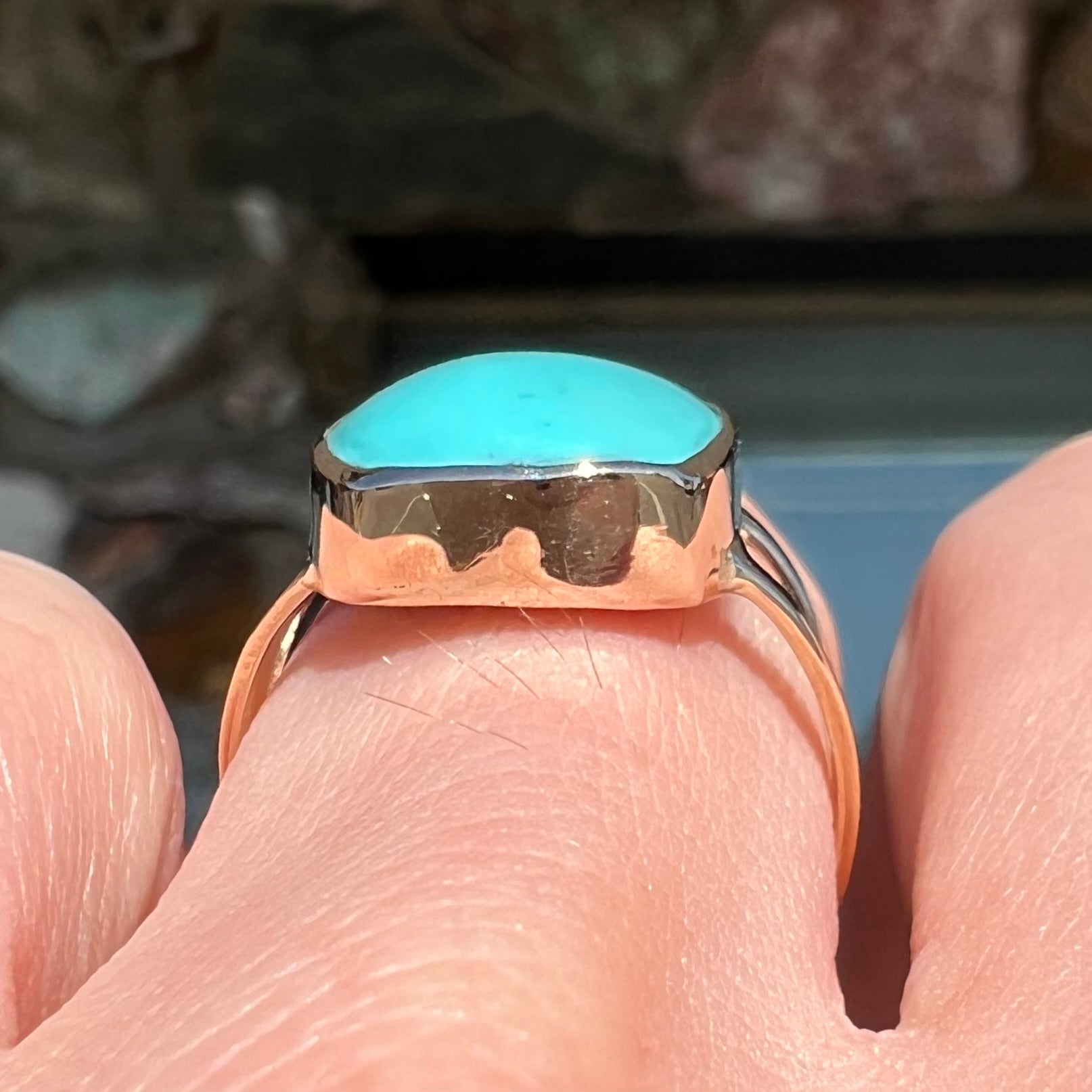 A handmade split shank ring set with Sleeping Beauty turquoise in yellow gold.