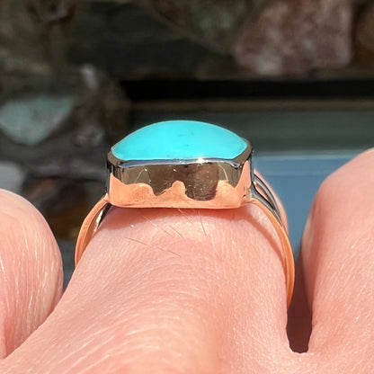 A handmade split shank ring set with Sleeping Beauty turquoise in yellow gold.
