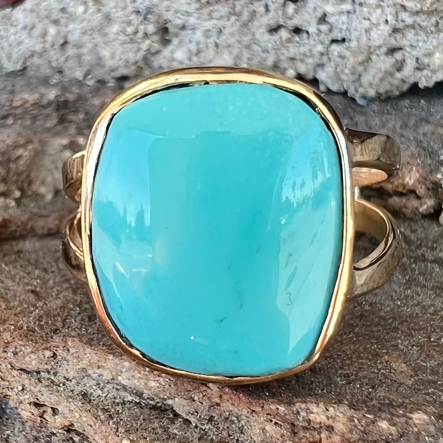 A handmade split shank ring set with Sleeping Beauty turquoise in yellow gold.
