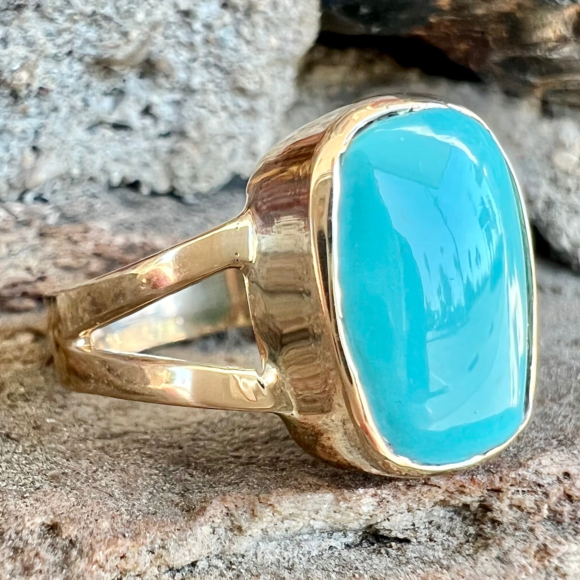 A handmade split shank ring set with Sleeping Beauty turquoise in yellow gold.
