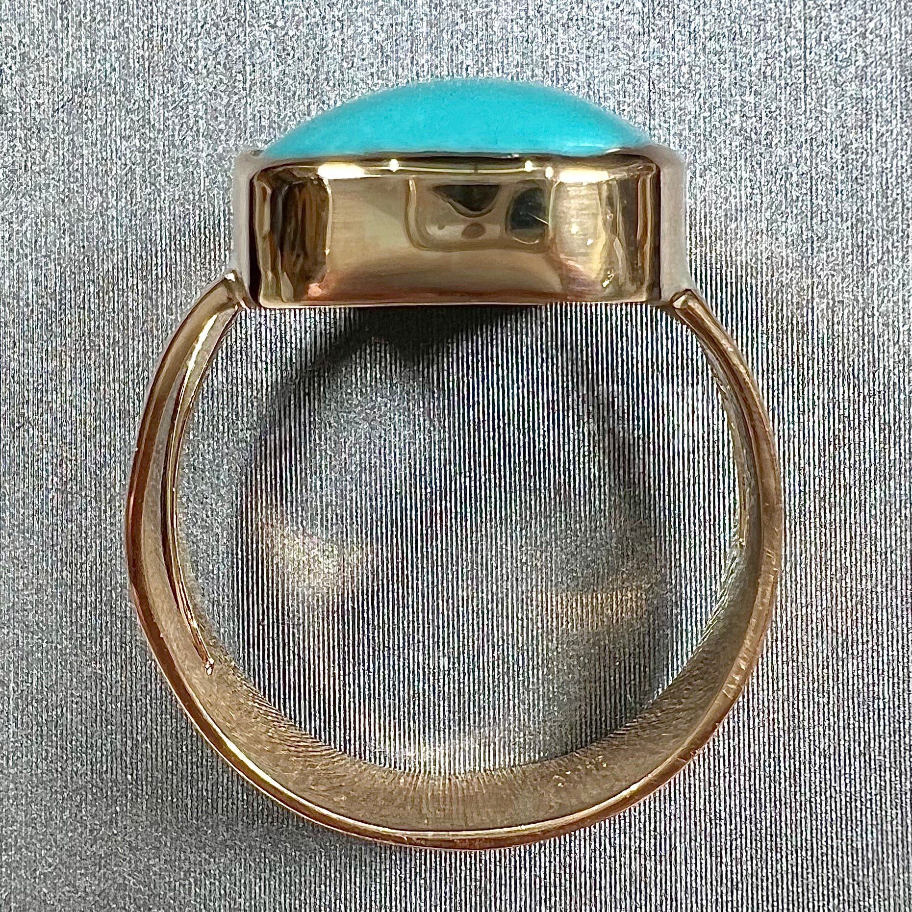 A handmade split shank ring set with Sleeping Beauty turquoise in yellow gold.