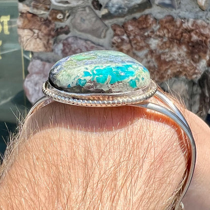 A handmade sterling silver cuff bracelet set with a single stone formed from variscite, chrysocolla, and azurite.