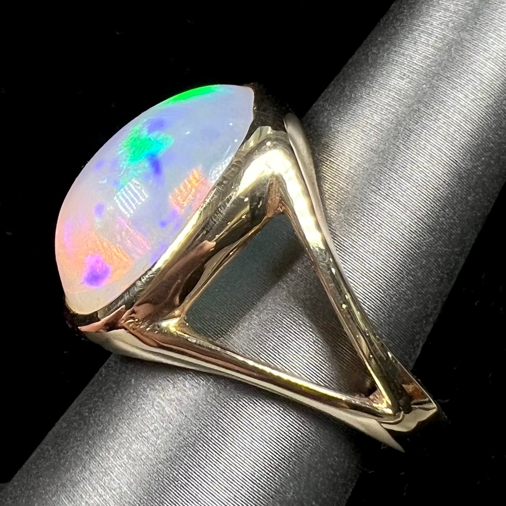 A gold split shank solitaire ring set with an oval cabochon cut 16.83 carat Ethiopian jelly fire opal.