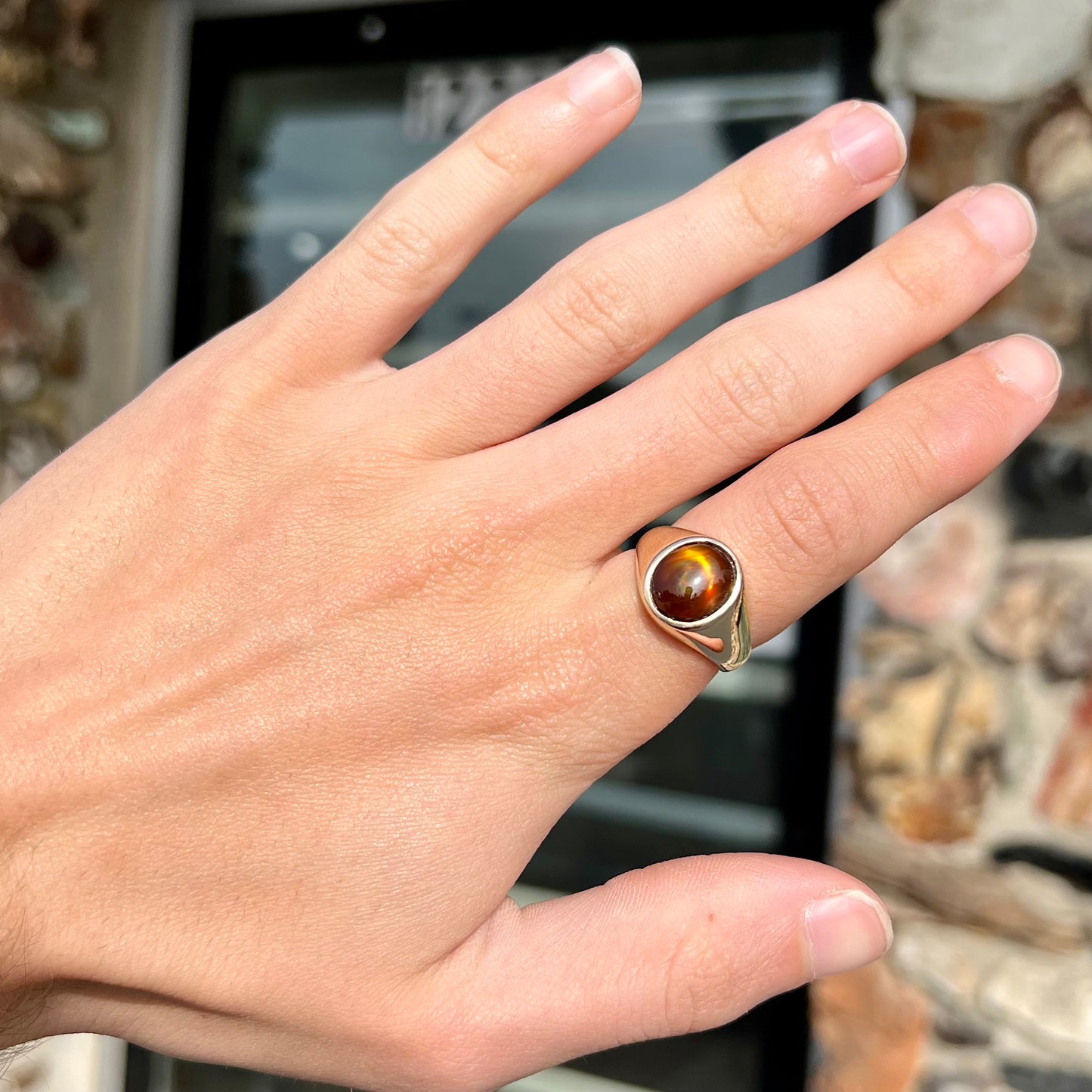 A unisex yellow gold flush set fire agate solitaire ring.