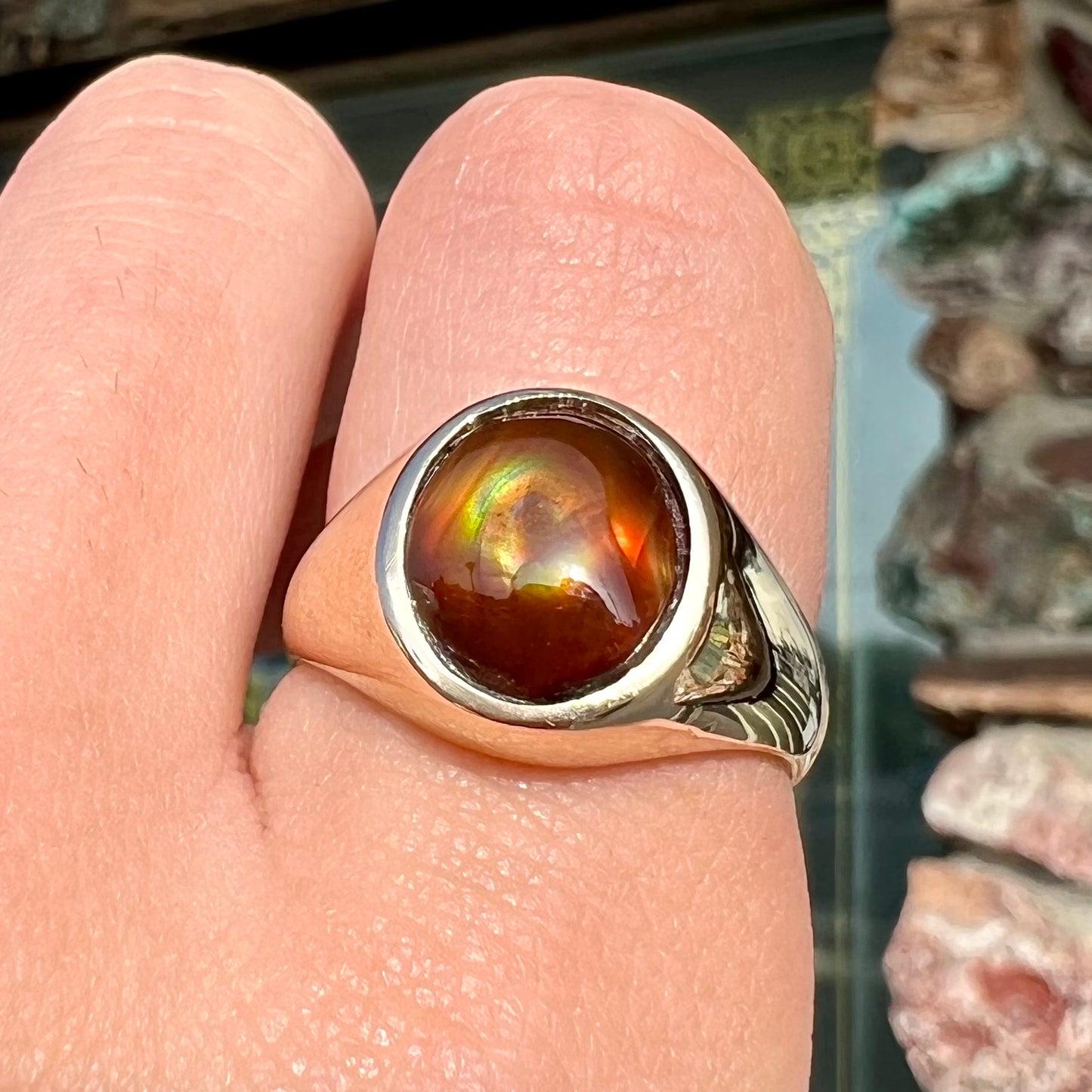 A unisex yellow gold flush set fire agate solitaire ring.