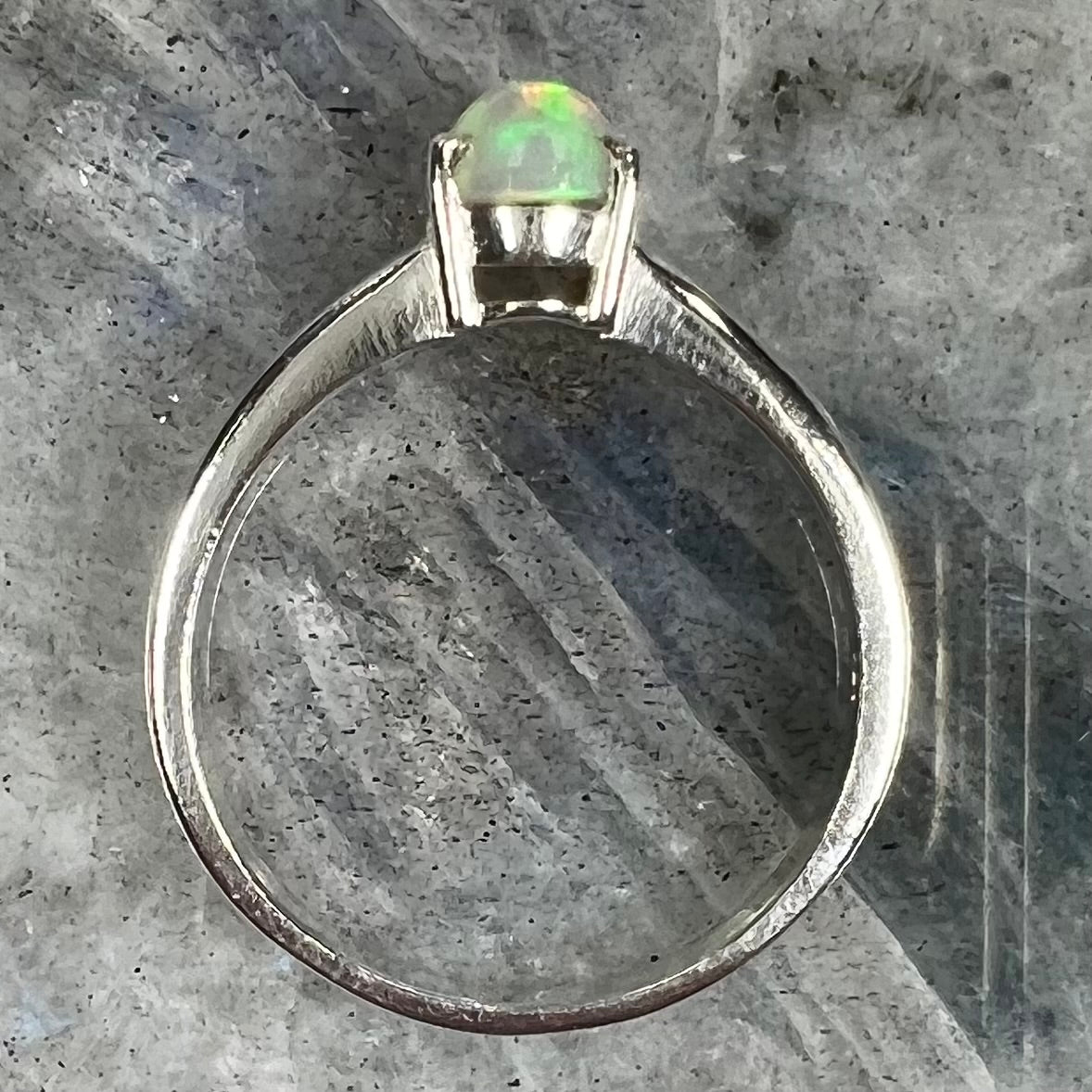 A silver, prong set, oval cabochon cut Ethiopian opal solitaire ring.