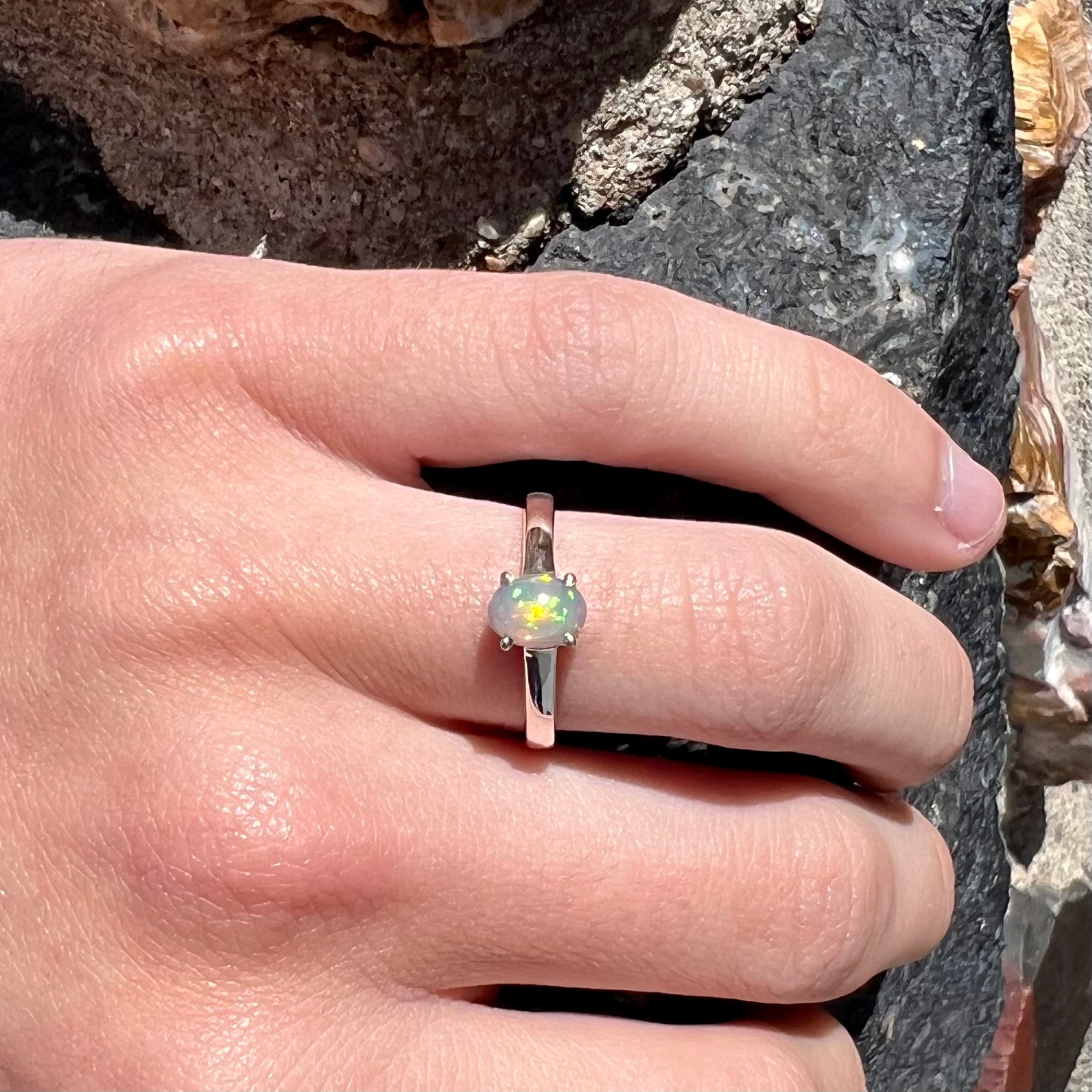 A silver, prong set, oval cabochon cut Ethiopian opal solitaire ring.