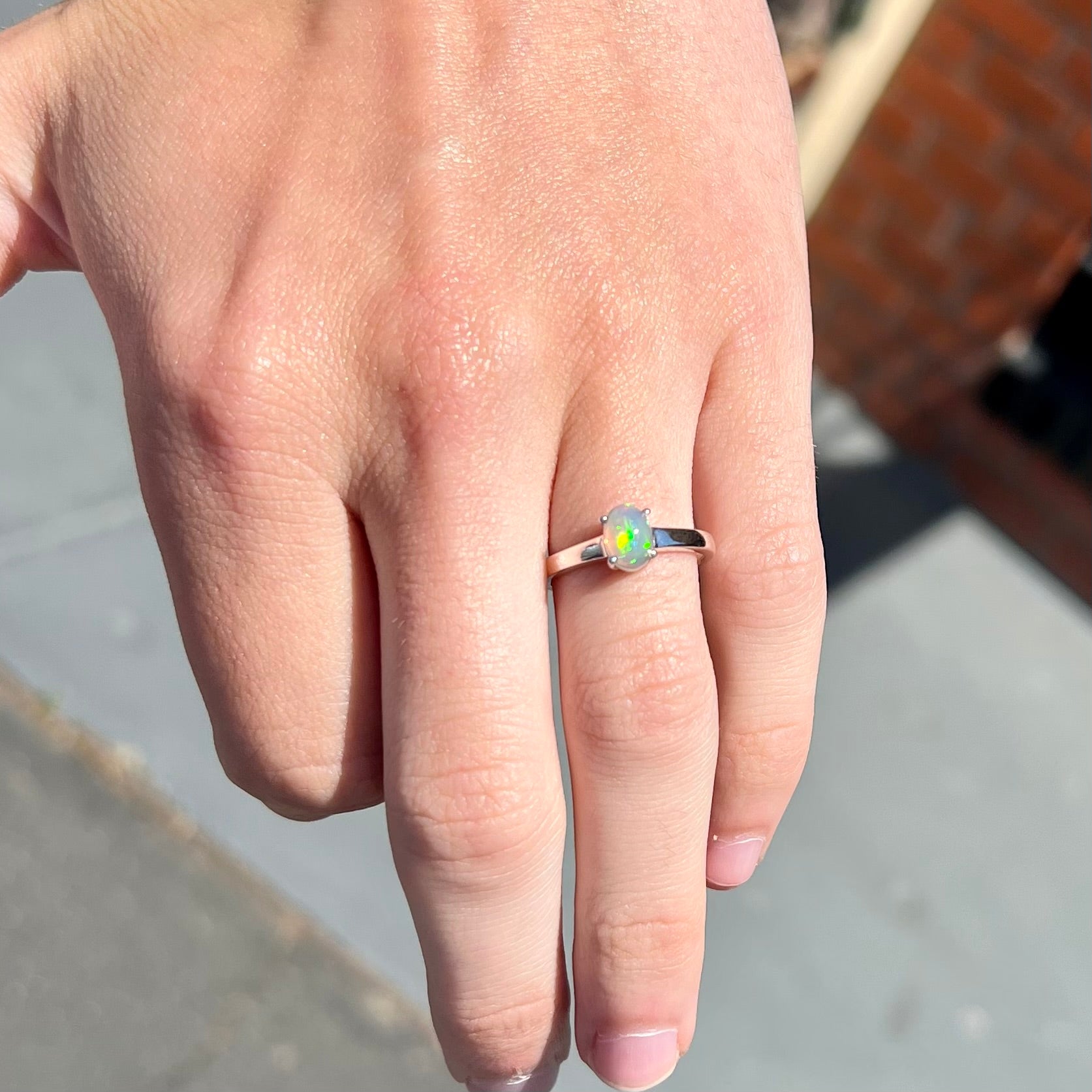 A silver, prong set, oval cabochon cut Ethiopian opal solitaire ring.