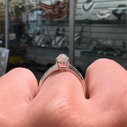 A silver, prong set, oval cabochon cut Ethiopian opal solitaire ring.