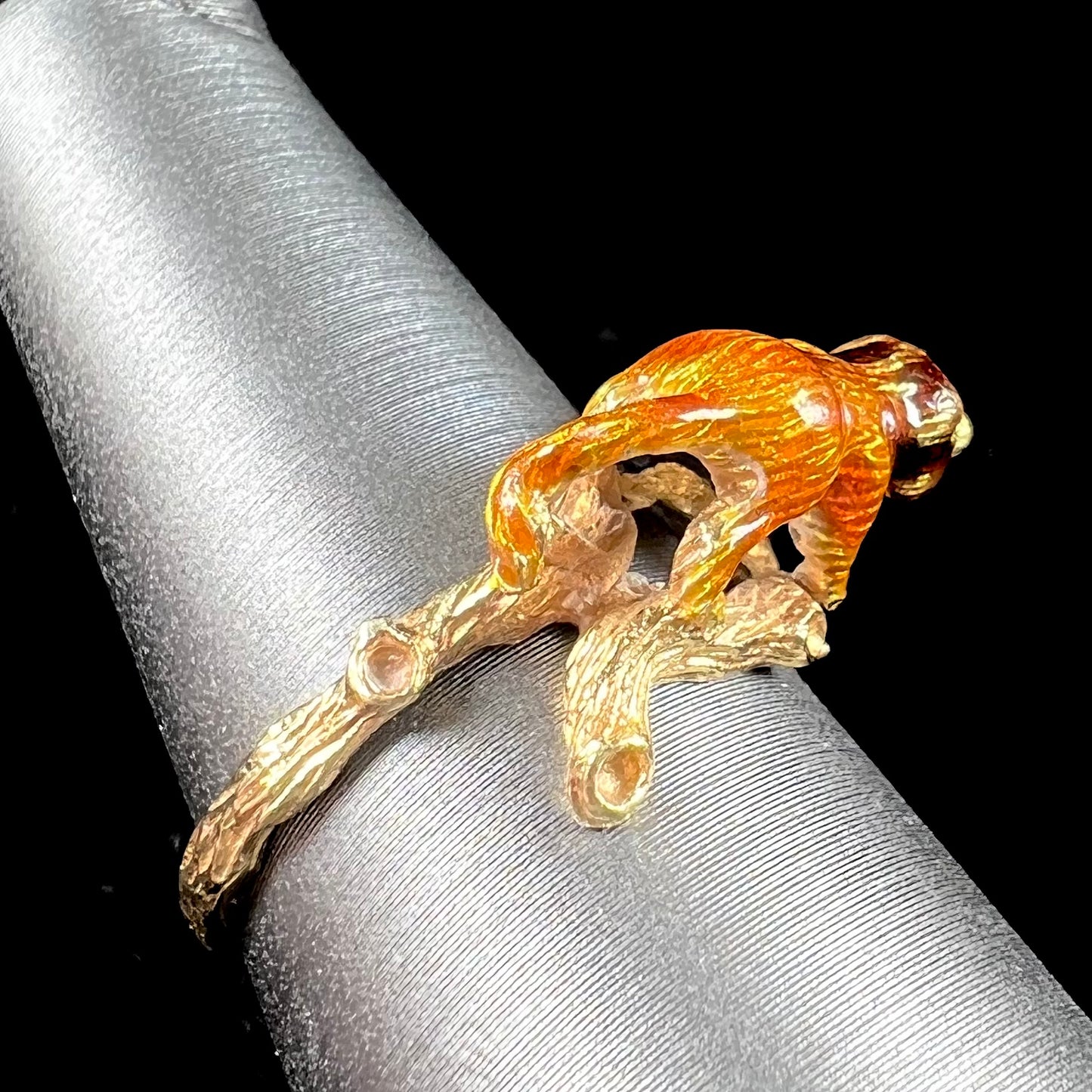 An estate 18kt yellow gold ring featuring a 3D enameled lion walking on a tree branch.