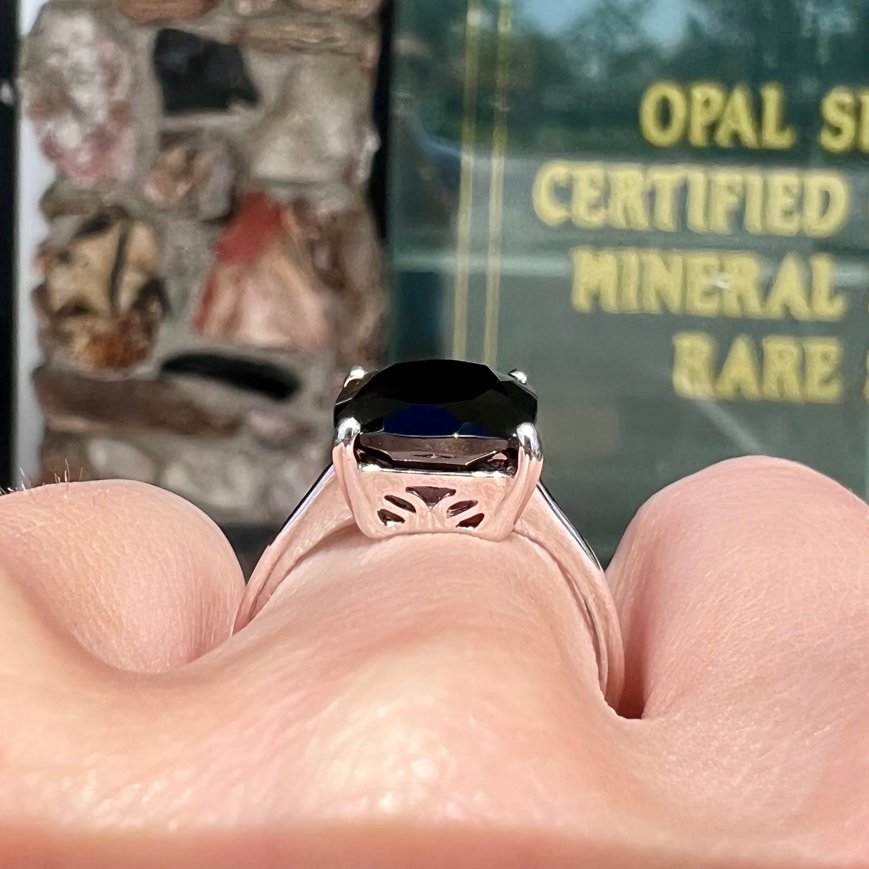 A cushion cut black spinel prong set in a sterling silver solitaire ring.