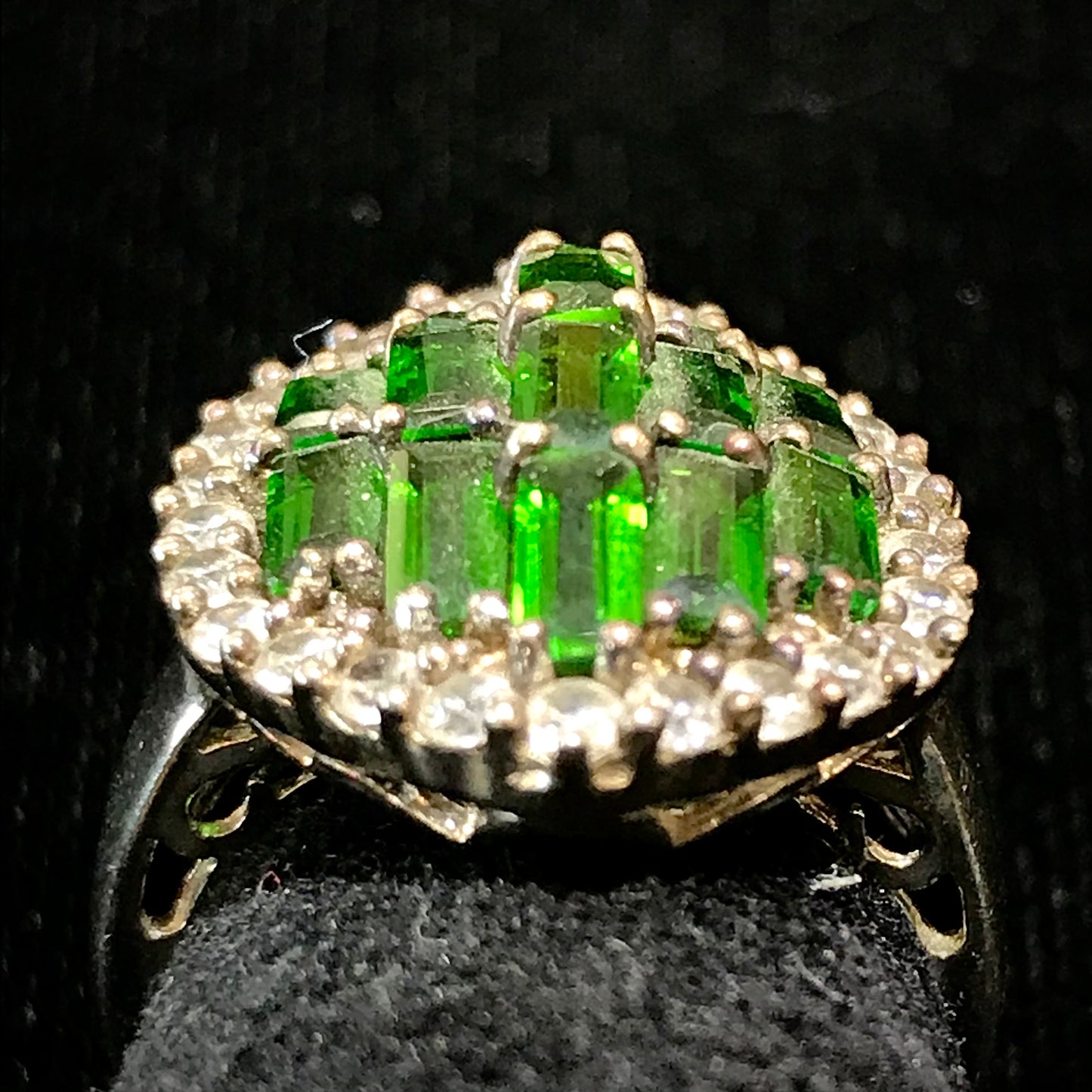 A sterling silver marquise shape ring set with green baguette cut stones.