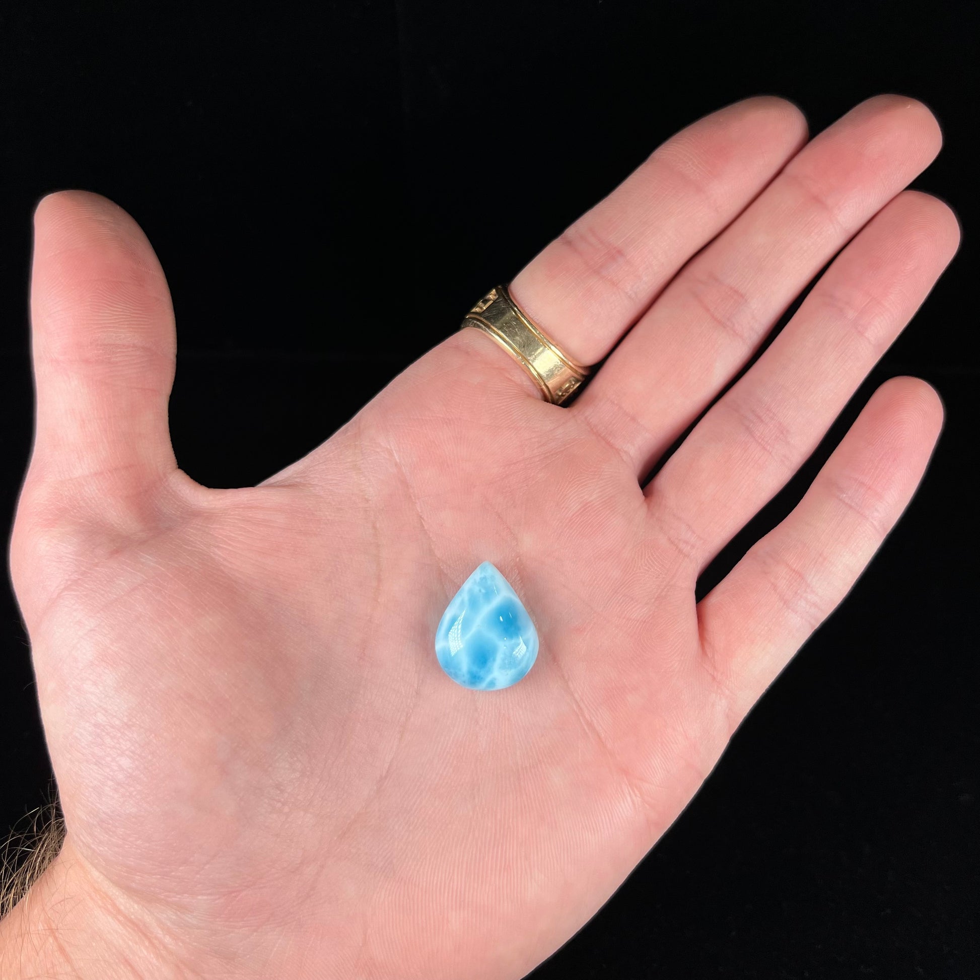 A cabochon cut, pear shaped, natural larimar stone from Dominican Republic.