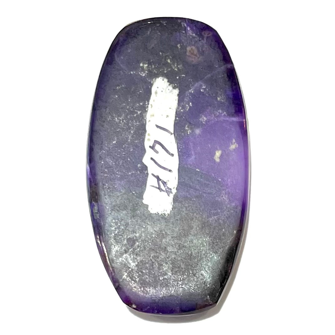 A loose, barrel cabochon cut purple sugilite stone.