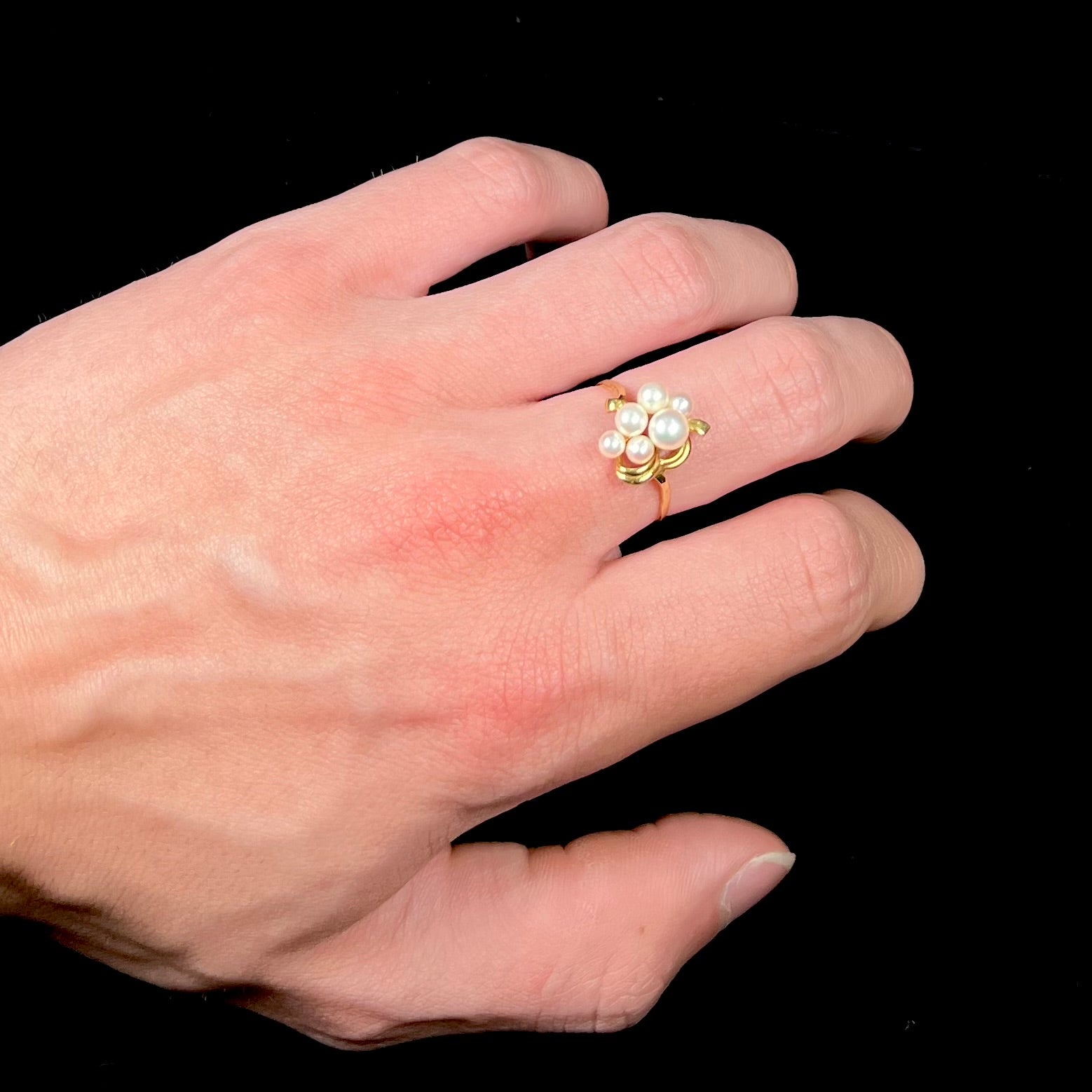 A yellow gold Akoya pearl cluster ring.  The pearls are round with pink overtones and resemble bubbles.