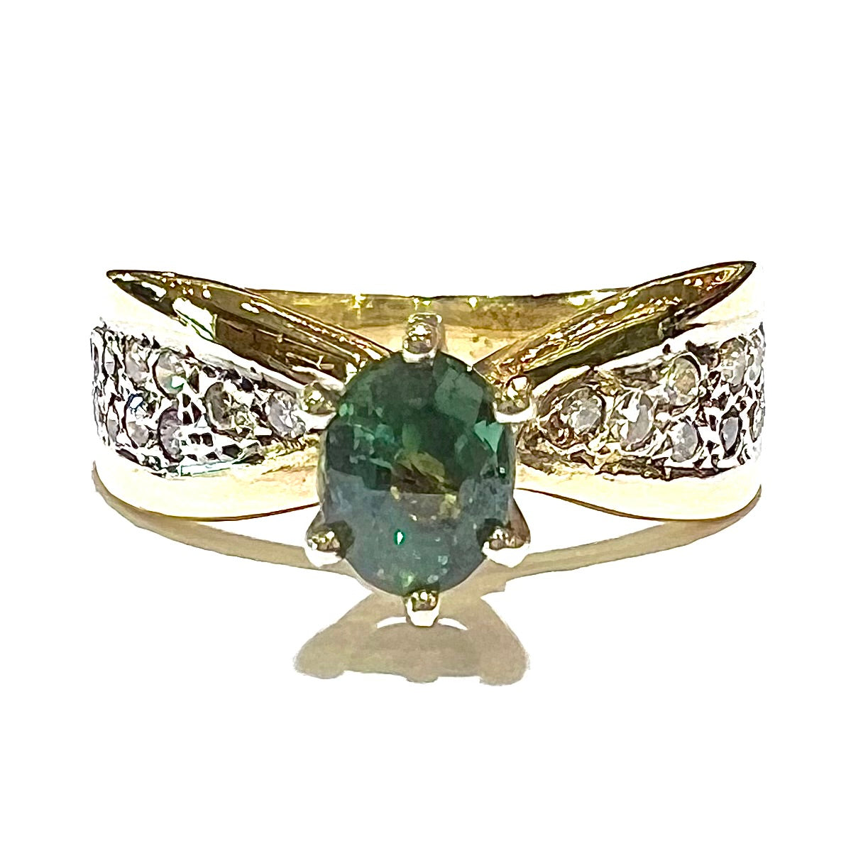 Natural alexandrite set in six prong yellow gold setting with pave diamonds.