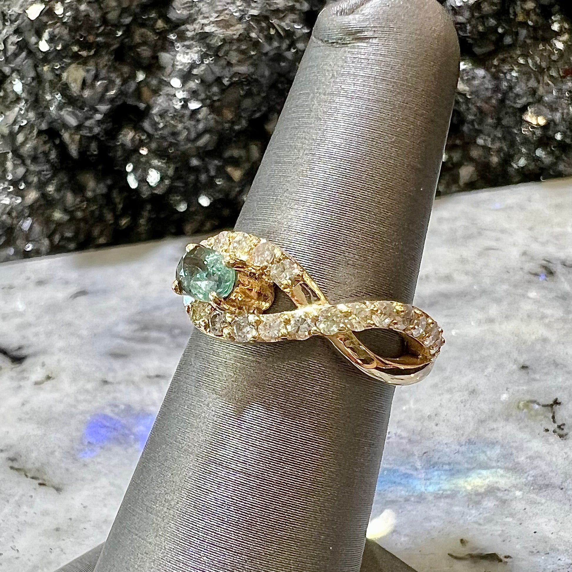 Yellow gold alexandrite and pave set diamond ring on ring stand.