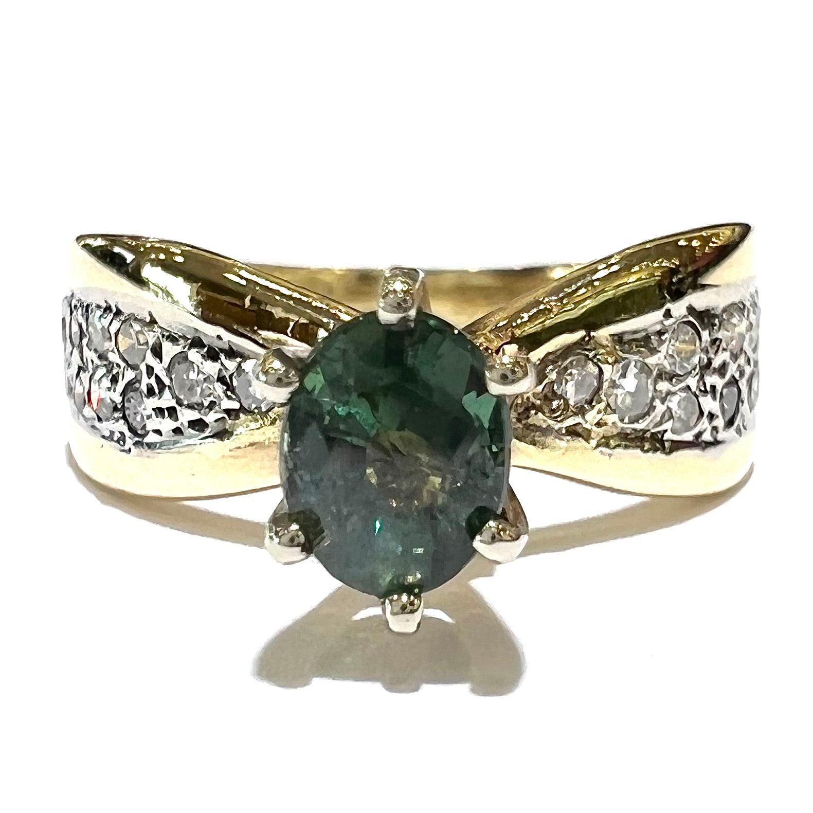 Natural alexandrite set in six prong yellow gold setting with pave diamonds.