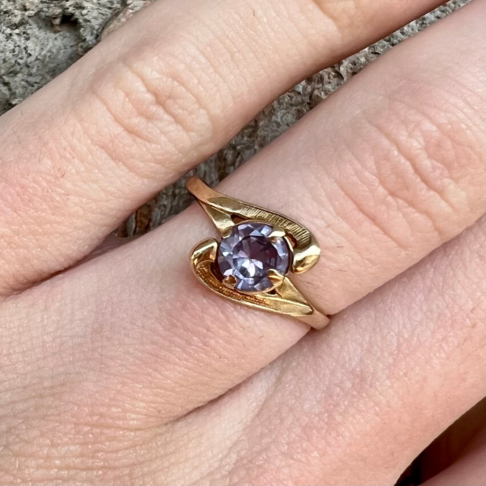 A vintage 1960's yellow gold ring set with a round synthetic purple alexandrite.  The prongs are worn.
