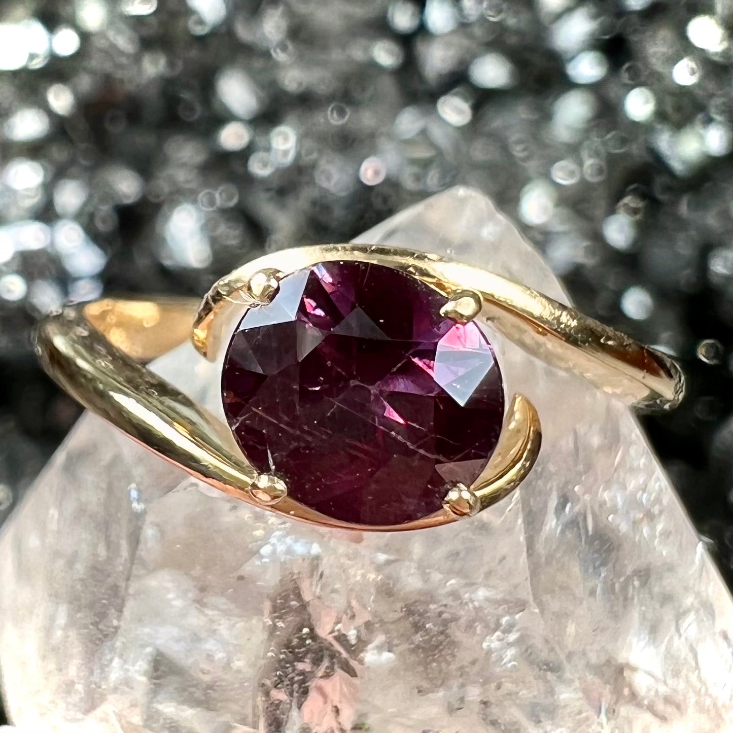 A yellow gold solitaire engagement ring set with a faceted oval cut color change garnet stone.