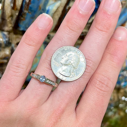 A ladies' white gold and diamond ring set with a 0.26ct alexandrite center stone that changes from green blue to lilac purple.