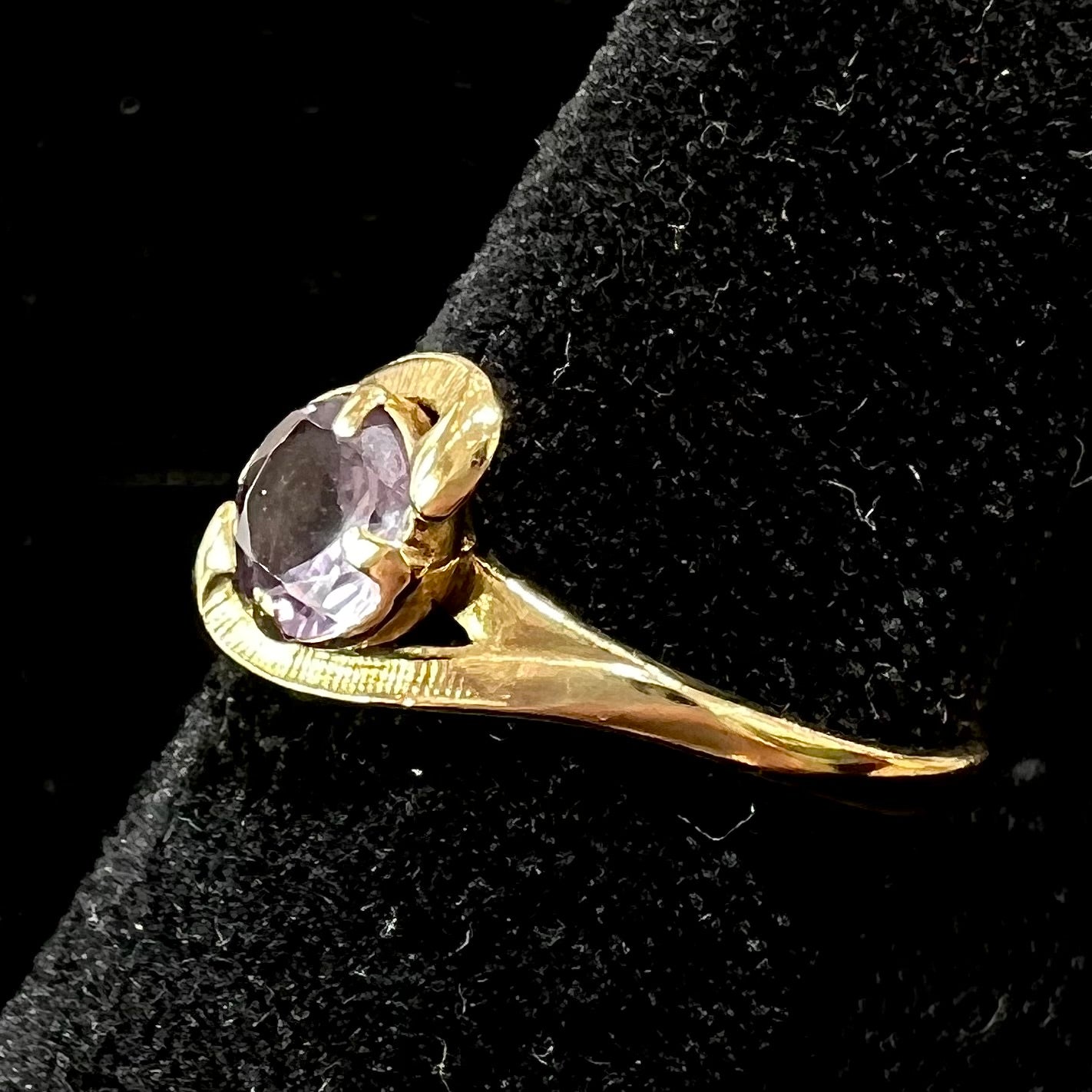 A vintage 1960's yellow gold ring set with a round synthetic purple alexandrite.  The prongs are worn.