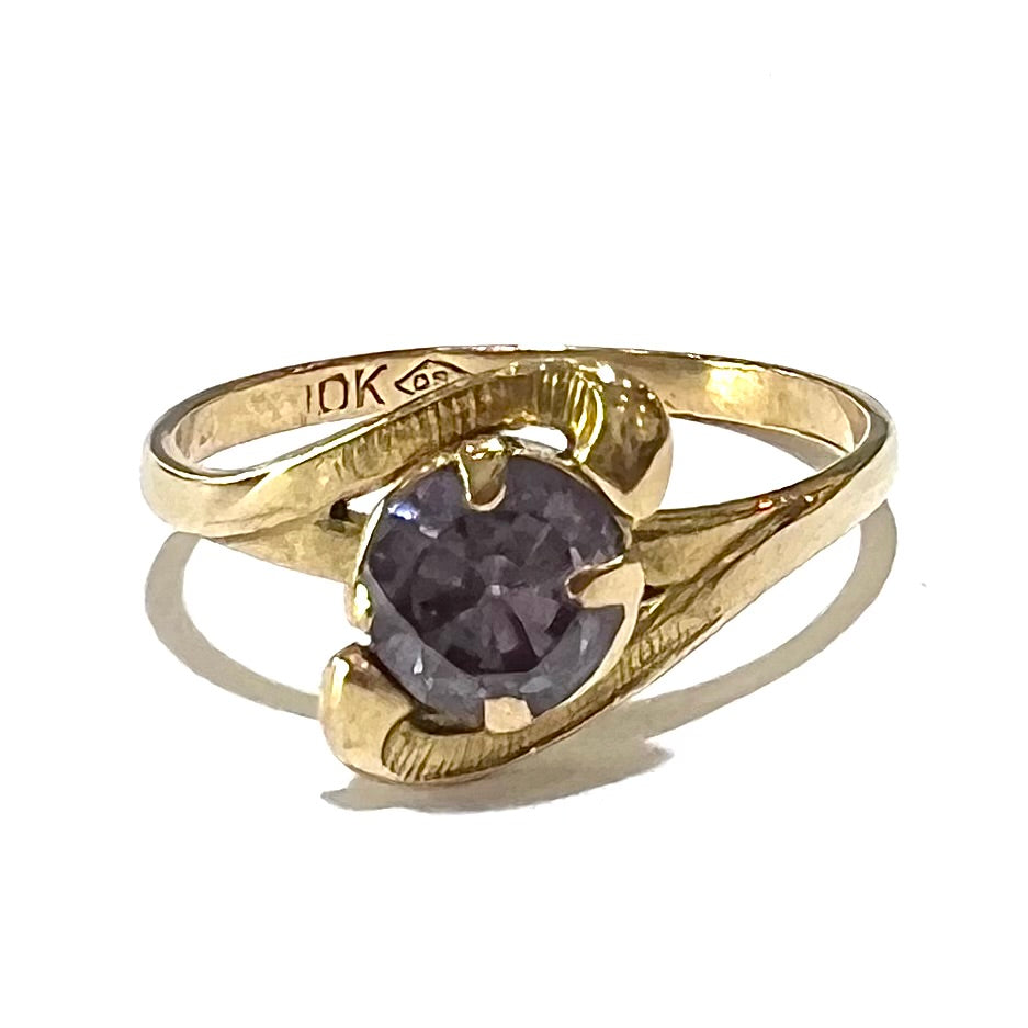 A vintage 1960's yellow gold ring set with a round synthetic purple alexandrite.  The prongs are worn.
