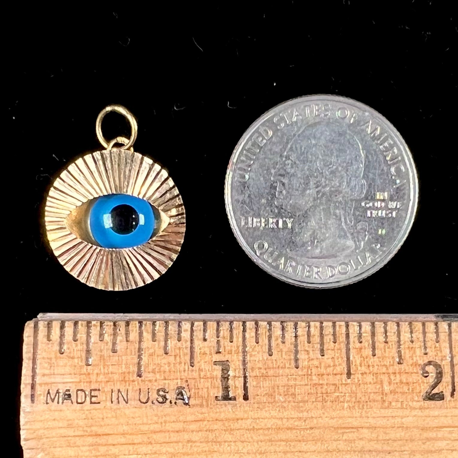 An 18kt yellow gold all-seeing eye pendant with a moving glass eye.