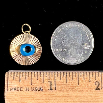 An 18kt yellow gold all-seeing eye pendant with a moving glass eye.