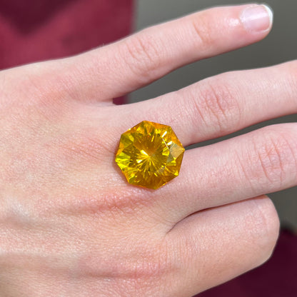 A loose, faceted octagonal cut golden amber stone.  There are no bug inclusions visible.