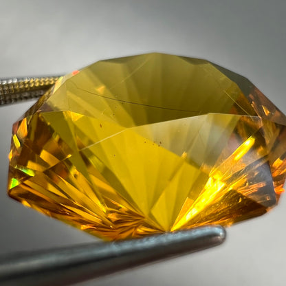 A loose, faceted octagonal cut golden amber stone.  There are no bug inclusions visible.