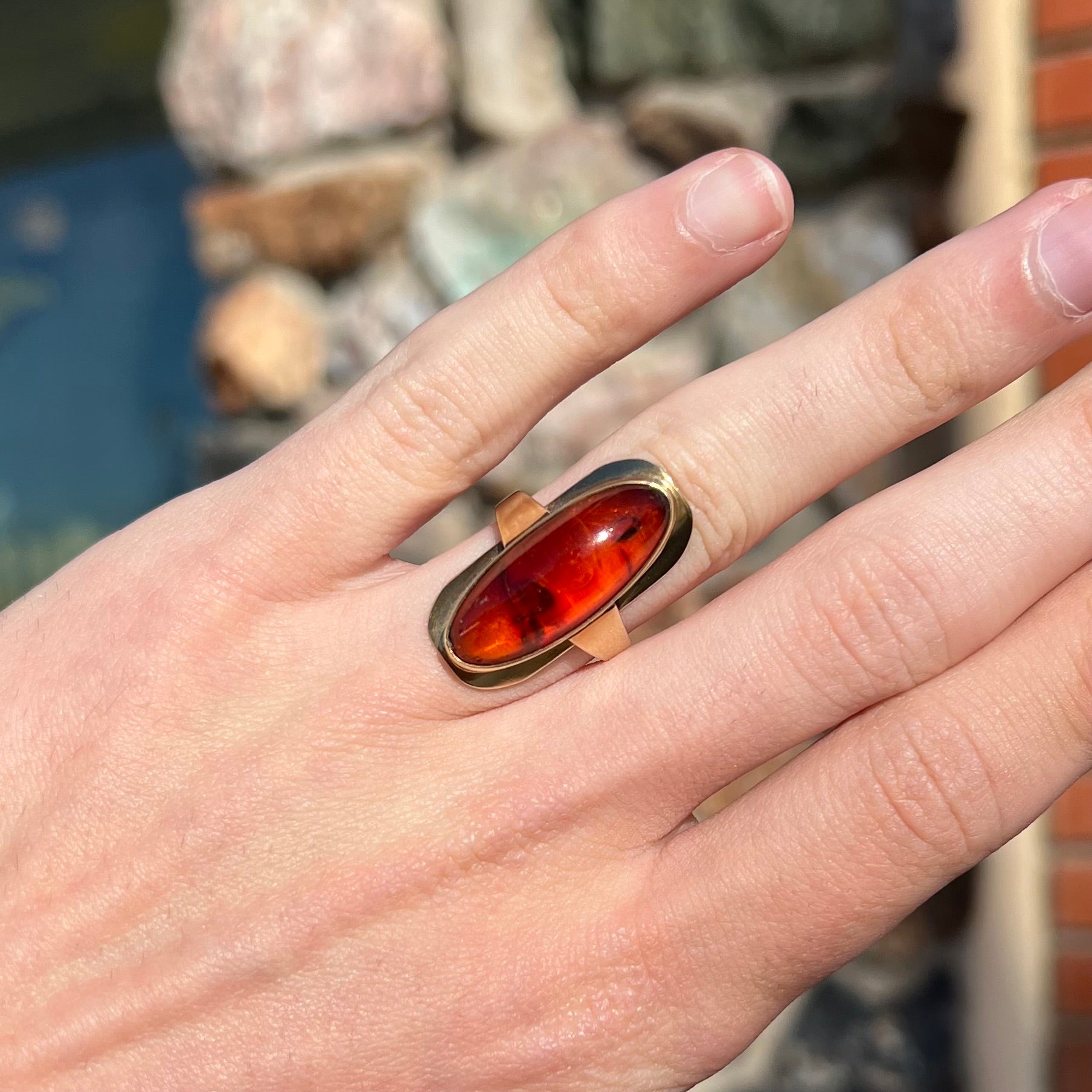 An oval cabochon cut Baltic amber stone set in a yellow gold ring and stamped "AMBER GUILD."