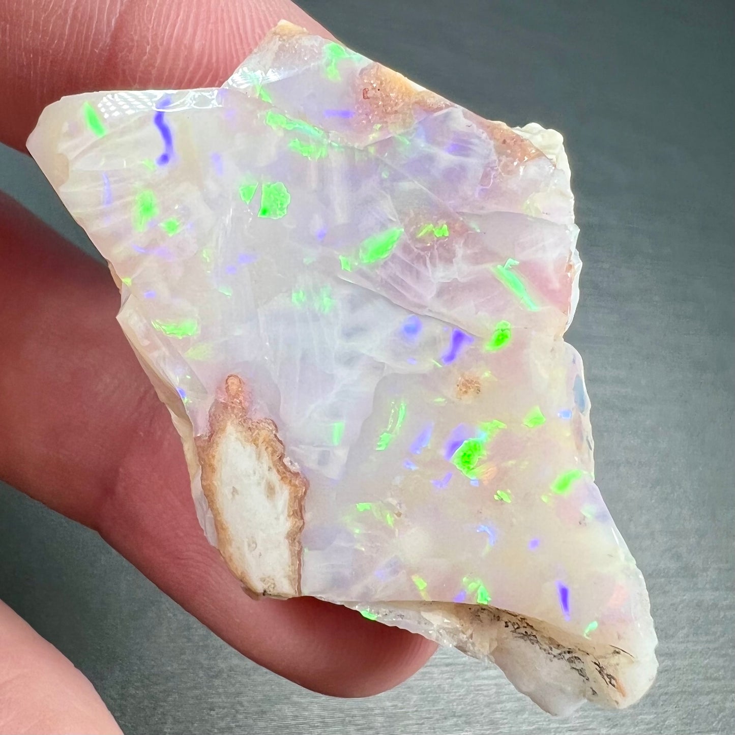 A loose, polished specimen of white crystal opal from Spencer, Idaho, USA.