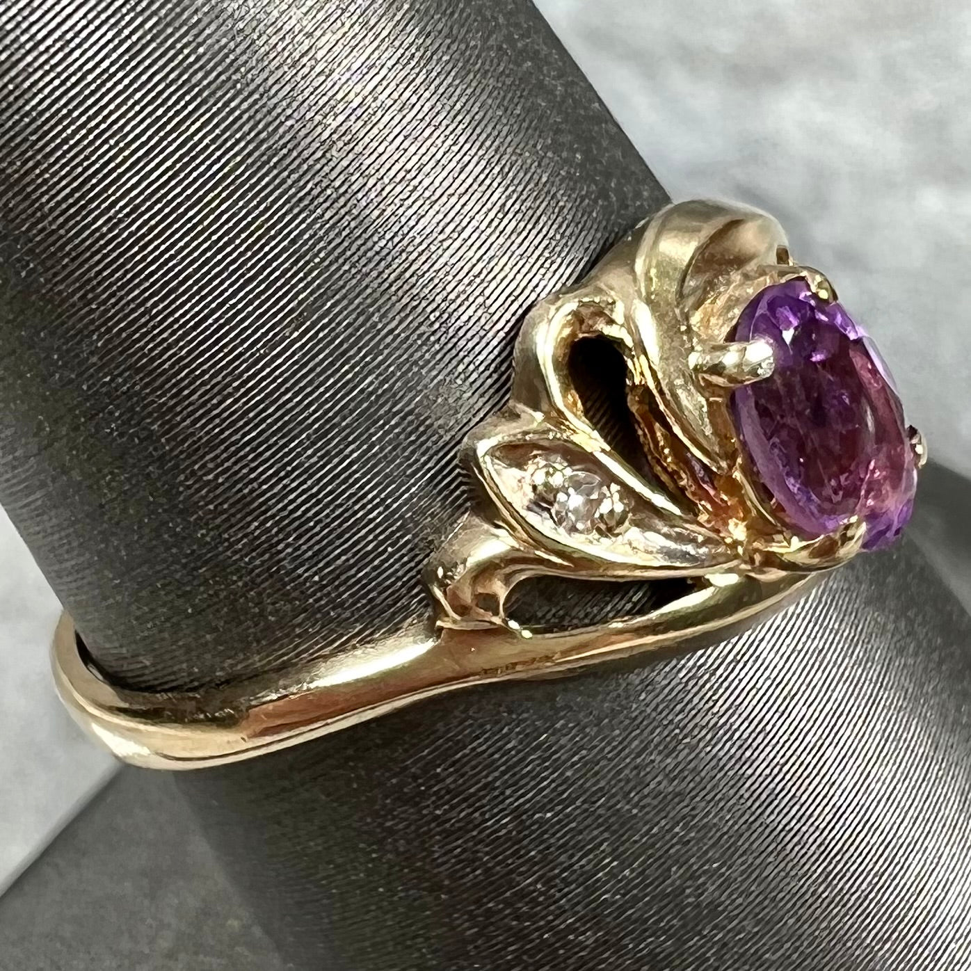 A yellow gold oval cut amethyst and diamond accent ladies' ring.