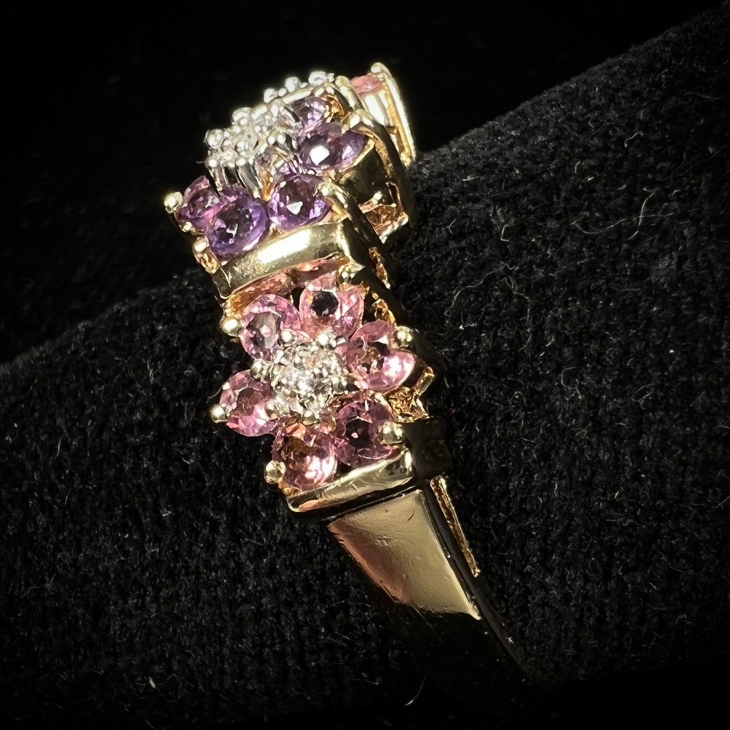 A vintage ladies' flower ring set with set with amethyst and pink tourmaline petals with a diamond center stone.